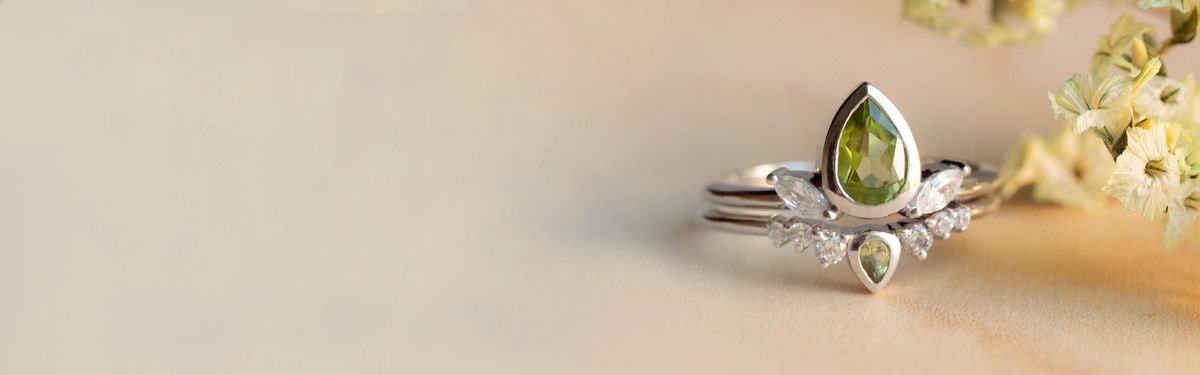 anillo de compromiso de peridoto en forma de pera con piedras laterales de diamantes de talla marquesa