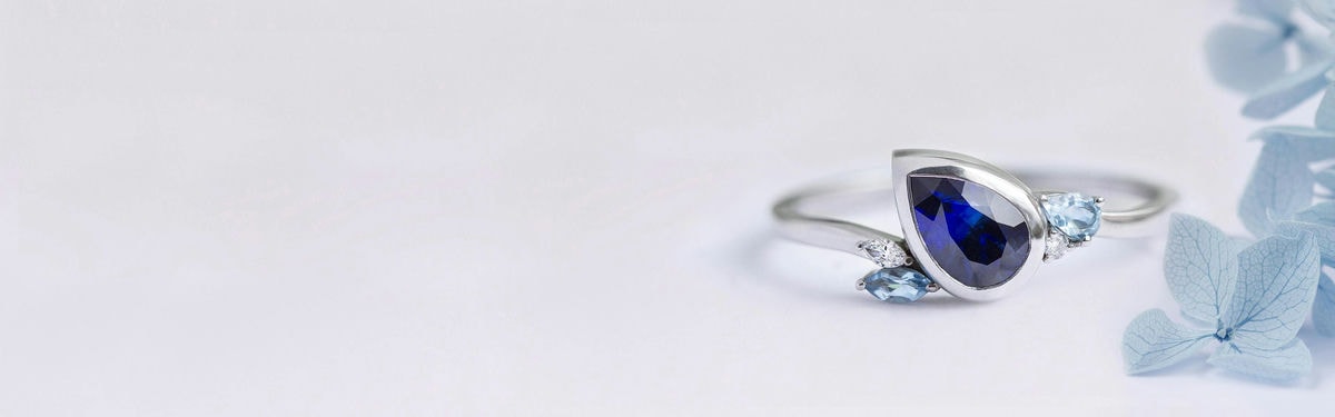 birnenförmiger Verlobungsring aus blauem Edelstein mit Aquamarinen und Diamanten