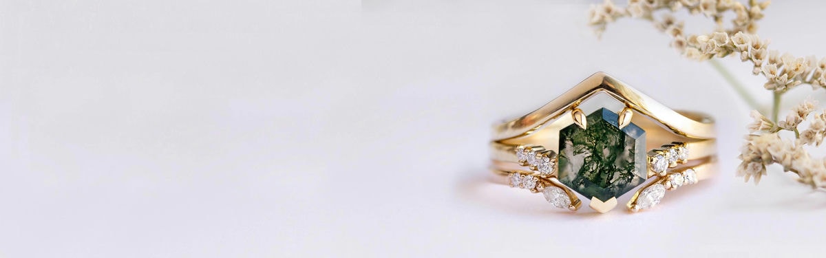 anillo de compromiso hexagonal con una banda abierta y un anillo con forma de V que forma un conjunto de anillos de boda de tres piezas