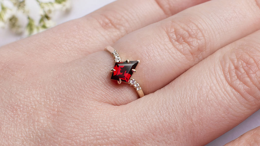 finished custom ring with red gemstone on a female finger