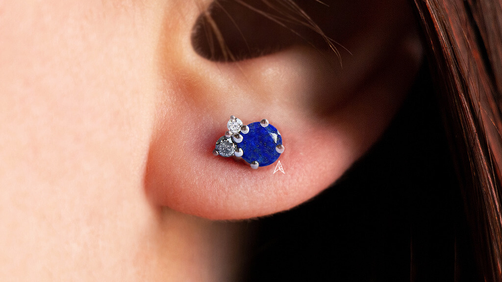 simple earring with a diamond, a round salt and pepper diamond and a round lapis lazuli gem