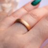 oro rosa ancho anillo de boda en el dedo