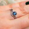 platino verde azulado zafiro anillo geométrico conjunto en la mano