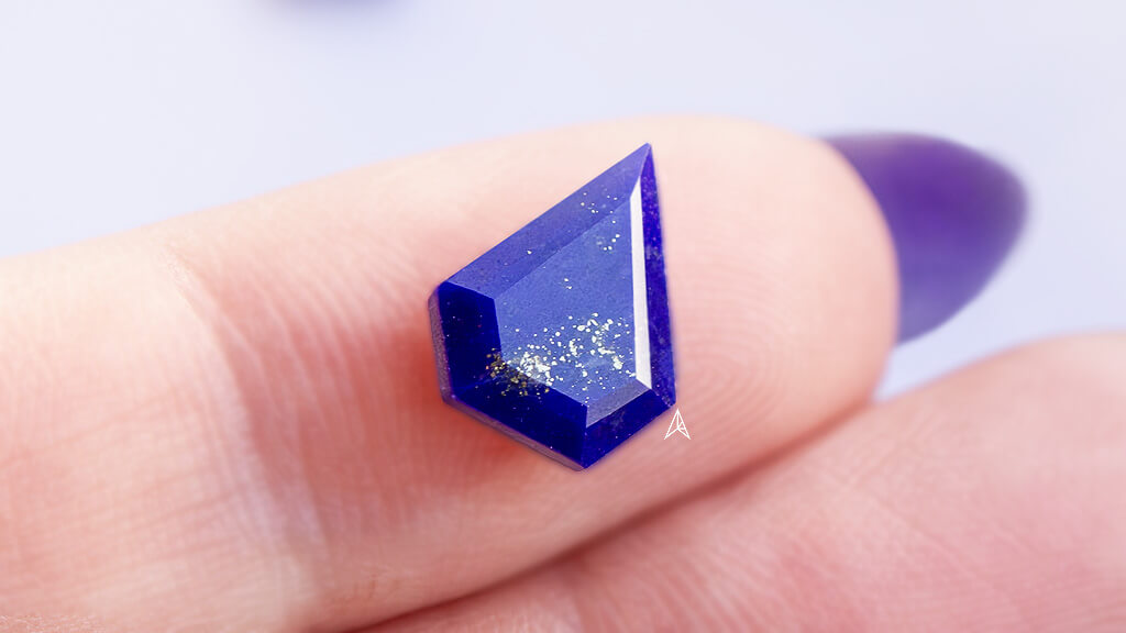 close up of a shield lapis lazuli gemstone on a finger